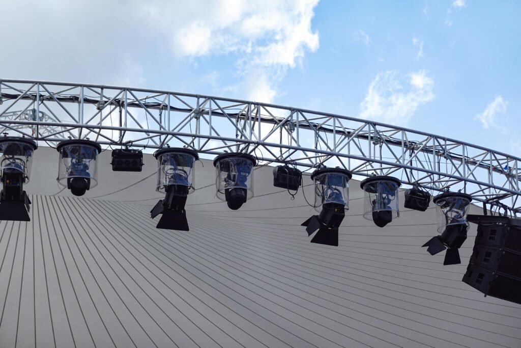 Overhead view of an outdoor stage with modern lighting setup against a blue sky.