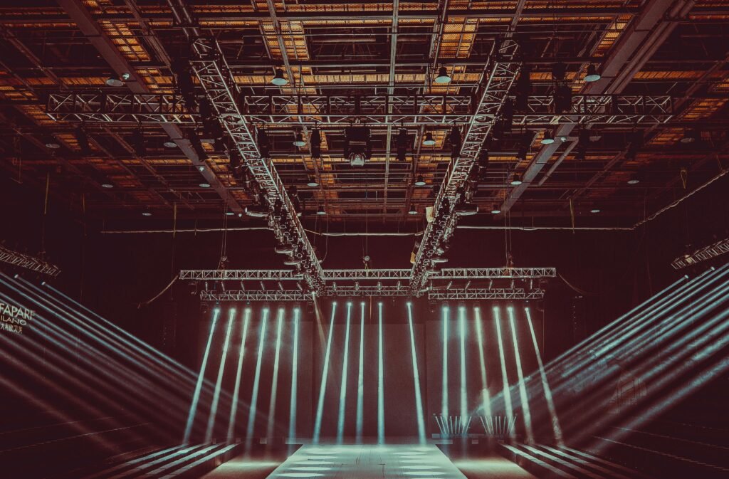 A contemporary indoor stage setup featuring dramatic lighting and intricate architectural patterns.
