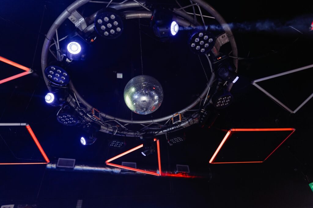Dynamic nightclub scene with colorful lights and disco ball overhead.